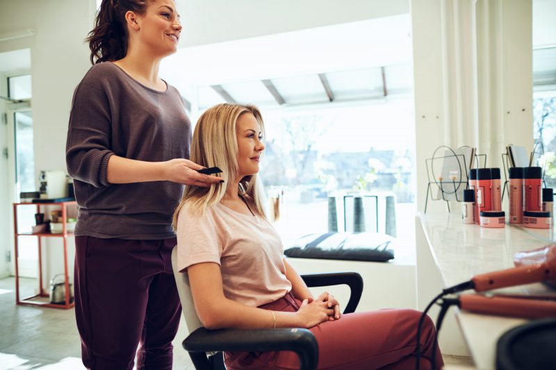 Smiling woman talking with her hairstylist in a salon Smiling woman talking with her hairstylist in a salon